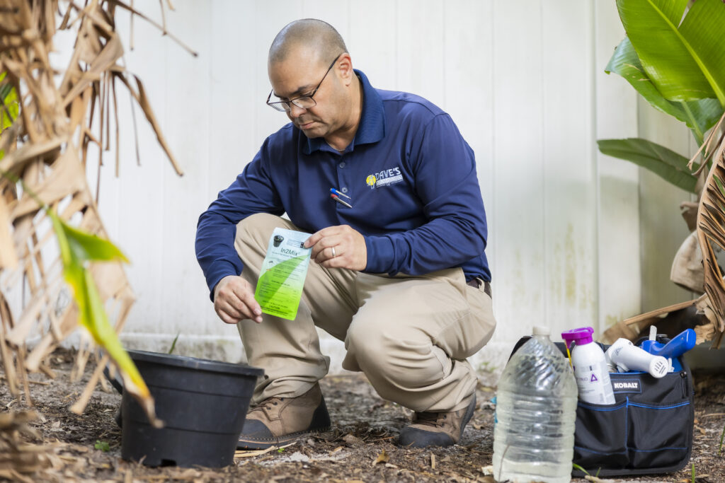 Dave’s Pest Control technician applying mosquito treatment in a Florida backyard