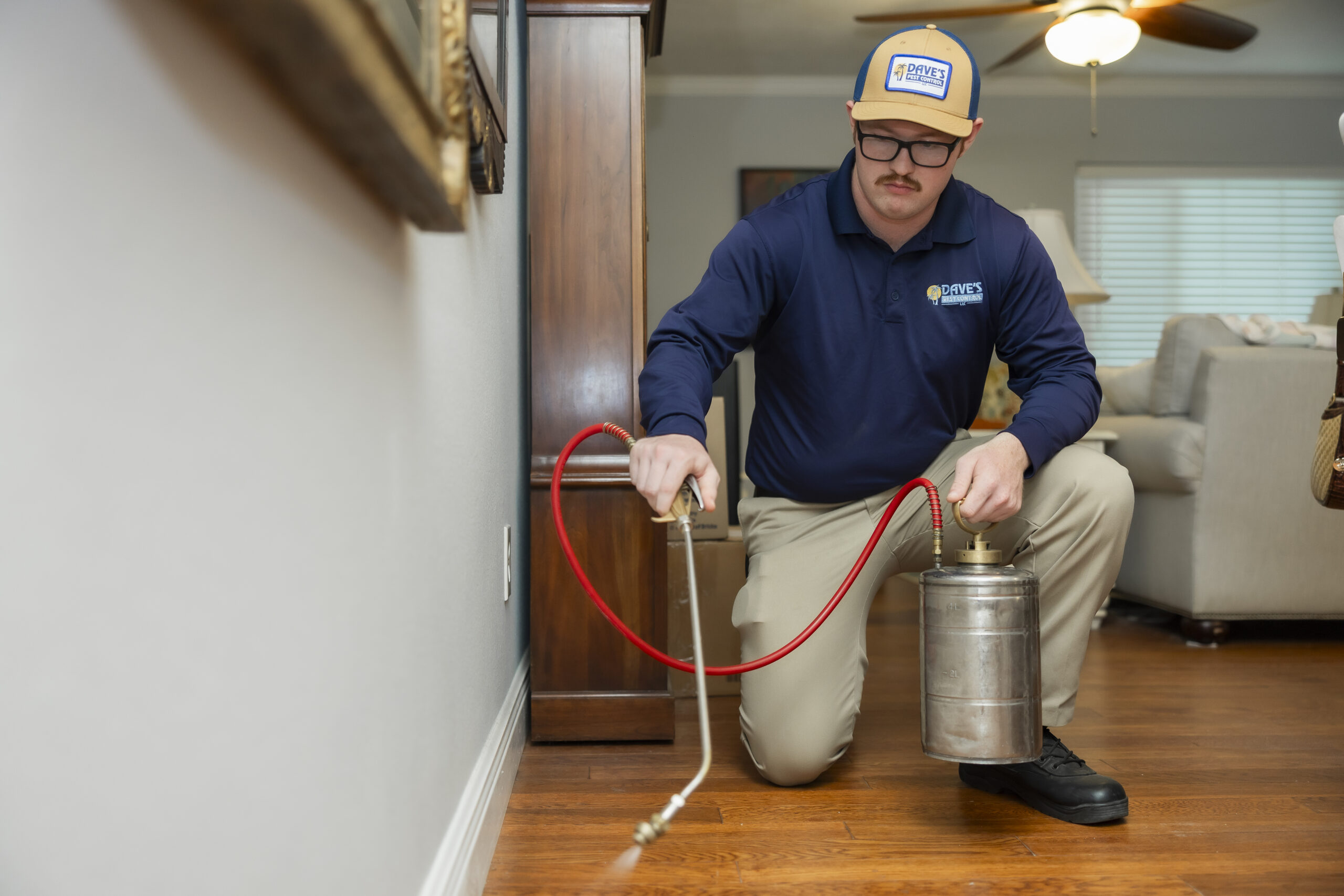 Shows a technician applying pest control inside a home