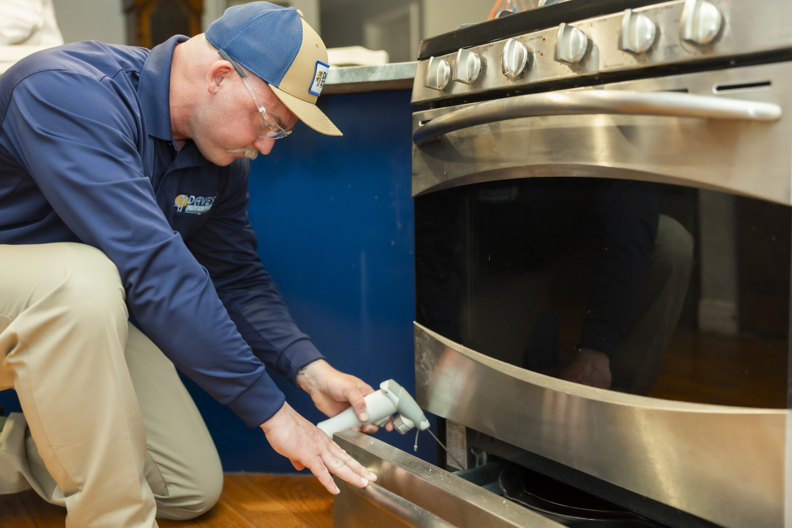Pest control technician applying treatment to control ants indoors